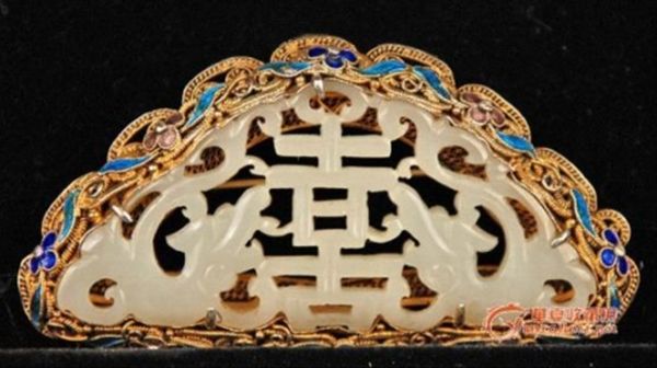 　　掐絲需具有靈巧的手上功夫，一把尖尖的鑷子，夾著一條纖細(xì)的銅絲，手指微微轉(zhuǎn)動(dòng)幾下之后，瞬間便化作朵朵金花、只只小鳥，以至湖光水色展現(xiàn)在器皿的胎型上時(shí)，無不為他們那絕妙高超的技藝而驚嘆。有很多白玉工藝品，使用這樣的高超工藝水準(zhǔn)配上溫潤的和田玉，哪是一個(gè)精美絕倫可以形容的，他們之間絕配的魅力不知能吸引多少青年男女的青睞。 圖為 清銀掐絲鎏金琺瑯嵌玉胸花。全品。《概述》玉為雙螭拱“喜”。一周為銀掐絲鎏金琺瑯<國內(nèi)也有稱燒藍(lán)>背后有“SILVER”，胸花是鎖扣有經(jīng)驗(yàn)的行家都知道，民國以后基本就不做這樣鎖扣了。尺寸：38*69MM。