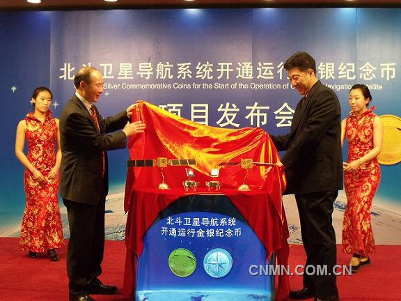 中國金幣總公司董事長徐聯(lián)初與總參測繪導(dǎo)航局衛(wèi)星導(dǎo)航定位工程辦公室主任楊寶峰共同為北斗衛(wèi)星導(dǎo)航系統(tǒng)開通運行金銀紀(jì)念幣揭幕