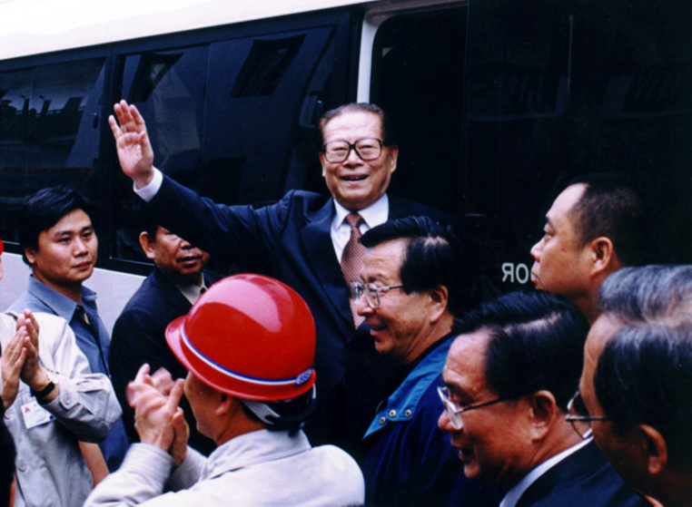 “同志們好！”“大家好！”邁出車門的江澤民向激動沸騰的西南鋁職工微笑地點頭，爽朗地問好，親切地揮手致意。（李影攝）
