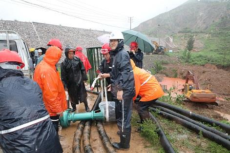 圖一為中州鋁業(yè)保障中心員工冒雨在現(xiàn)場搬運潛水泵設備，以應對未來幾天更加嚴峻的汛情。
